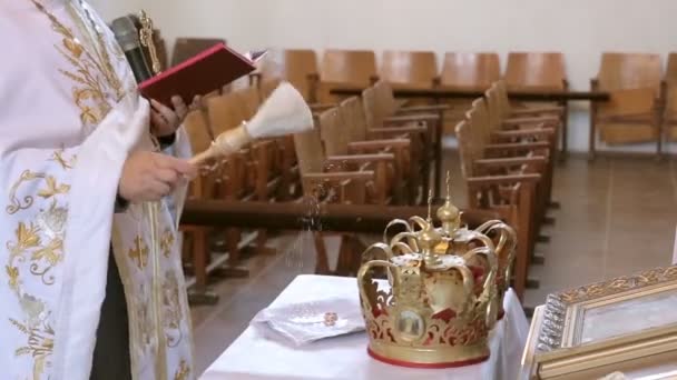 Priest blesses and spray water into two rings — Stock Video