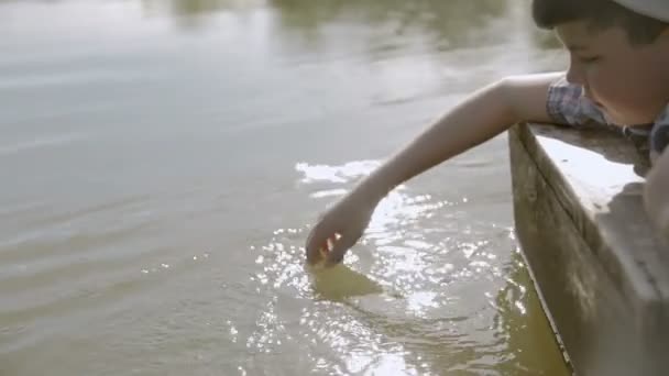 Boy in a hat holling hand in water — Stok Video