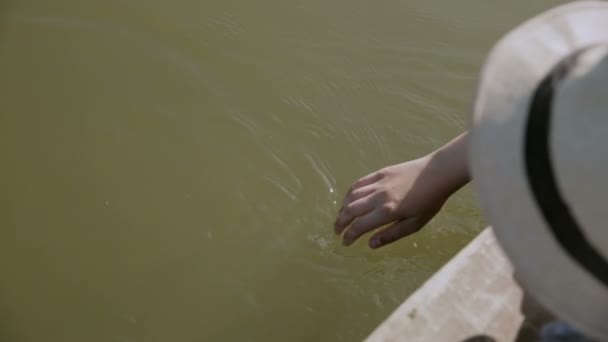 Niño jugando y mueve la mano en el agua — Vídeo de stock