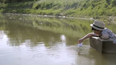 Kağıt tekne ile oynarken tekne, zavallı çocuk