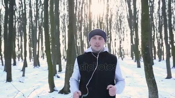 Cámara lenta: Atleta disfrutando de la música en trote de invierno — Vídeos de Stock