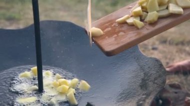 Adam büyük bir ısıtmalı tavada patatesleri atma.