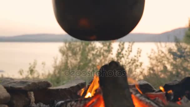 DOLLY MOTION: Cooking in a cauldron on fire. — Stock Video