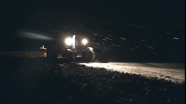Sen plöjning i slutet av November i snöfall. Traktor plöjer. — Stockvideo
