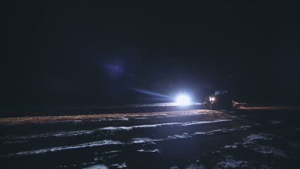 Laat ploegen aan het einde van November in zware sneeuwval. Trekker ploegen. — Stockvideo