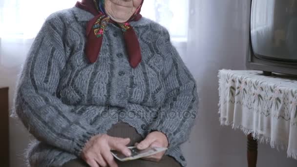 Mujer mayor parece fotos viejas. Tristeza — Vídeos de Stock