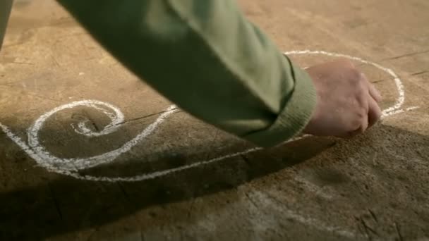 Close-up hand of a young blacksmith who draws a chalk sketch on the table — Stock Video