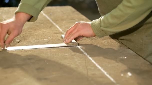 Un jeune forgeron utilise gon pour tracer une ligne sur la table — Video