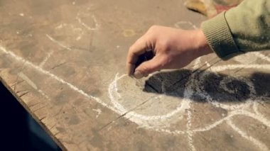 Yakın çekim el ile tebeşir kroki kontrplak üzerine çizer sanatçı