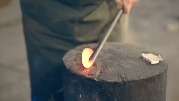 Kováři ohnout roztaveného kovu s kladivem na kovadlině v kovárně