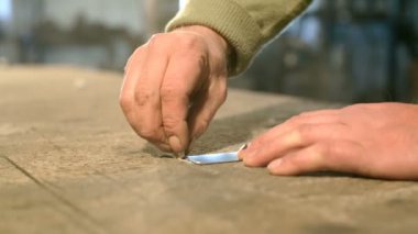 Yakın çekim el bir tebeşir hattı tablosuna metal cetvelle çizilir bir genç demirci.