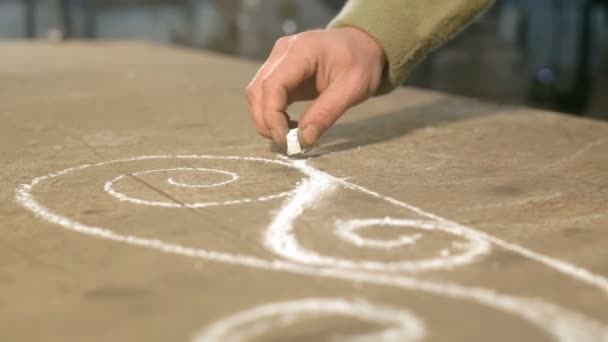 Gros plan main d'un jeune forgeron qui dessine un croquis à la craie sur la table — Video