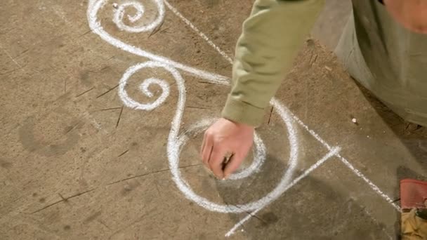 Mano de cerca de un joven herrero que dibuja un boceto de tiza sobre la mesa — Vídeos de Stock