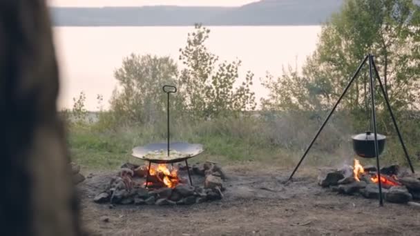 O homem derrama batatas com tábuas de madeira e uma grande frigideira quente. Batatas na grelha de disco . — Vídeo de Stock