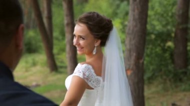 Mutlu yeni evliler el ele gider. Gelin etrafına bakıyor ve nişanlısı gülümsüyor