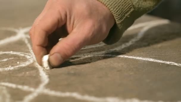 Gros plan main d'un jeune forgeron qui dessine un croquis à la craie sur la table — Video