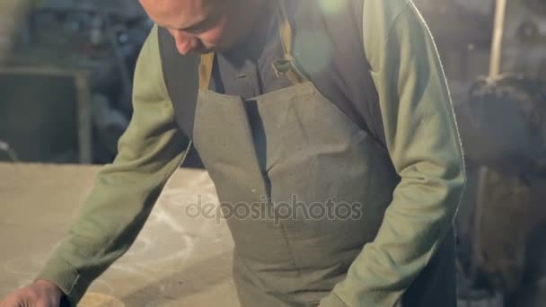 Un joven herrero mide la pieza de metal en su taller. Creación de productos forjados propias manos . — Vídeo de stock