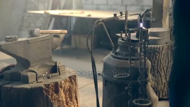 В кузнице зажег факел на наковальне — стоковое видео