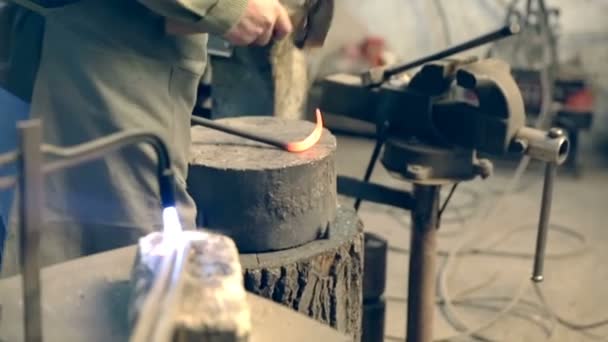 Kovář opracovává kov kladivem na kovadlině v kovárně — Stock video