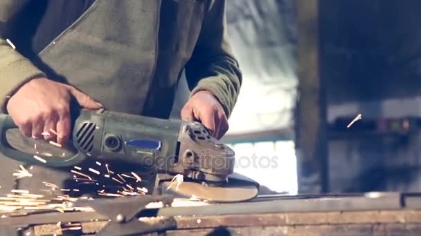 Trabajador de primer plano que utiliza amoladora industrial en piezas de riel metálico en almacén de taller industrial . — Vídeos de Stock