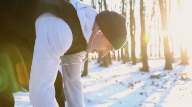 Profesyonel sporcu eğitim için ayakkabı bağcığı spor ayakkabısı Kulaklığımda günbatımında bağlama için eğildi