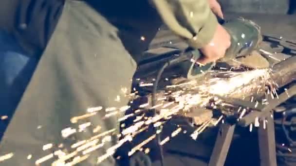 Lavoratore di primo piano che utilizza la smerigliatrice industriale su parti di binari metallici nel magazzino dell'officina industriale . — Video Stock