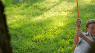 Köy adam güzel bahçede boyalı lastik, üzerinden bir salıncak sürmek. Ağır çekim