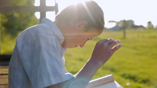 Мальчик мечтает с книгой — стоковое видео