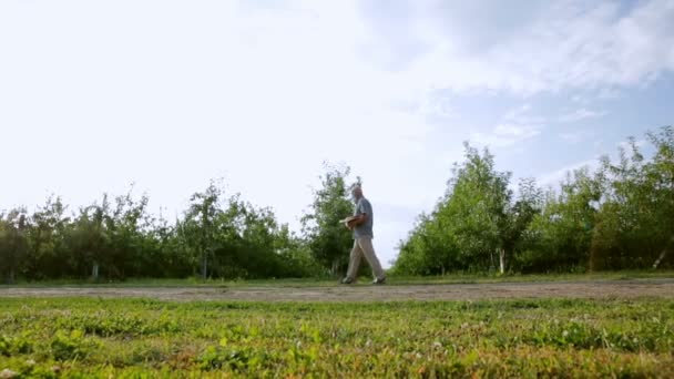 Twee mannen gaan naar boomgaarden — Stockvideo