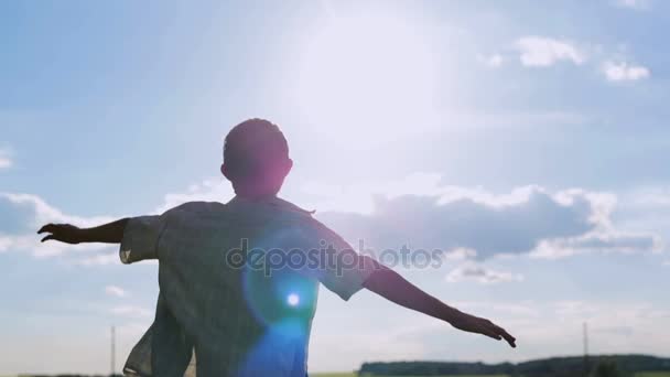 A carefree guy raised his arms, as if flying at sunset and in the summer — Stock Video