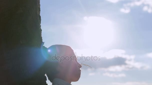 Kleine jongen dromen in de achtergrond van een zonnige hemel — Stockvideo