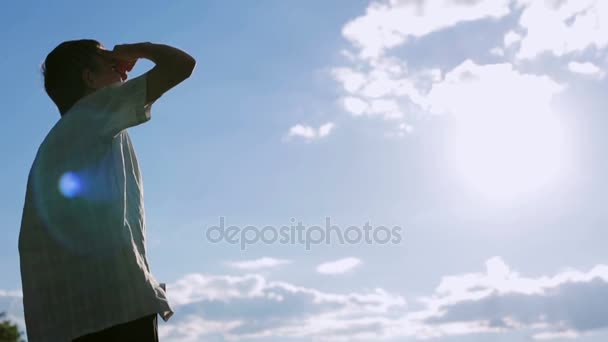 Küçük çocuk bakıyor sonsuz yaz gökyüzü ve gün batımı — Stok video