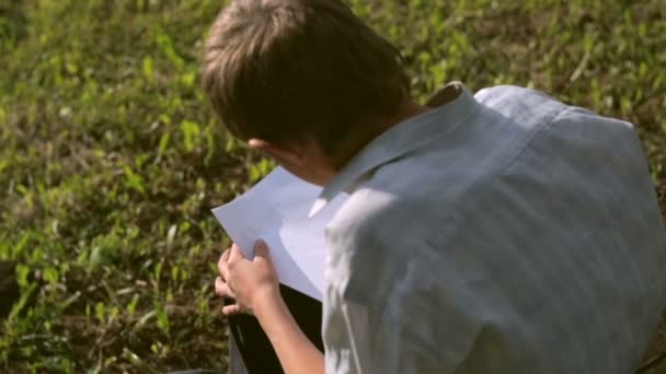 Ένα μικρό αγόρι με βρώμικα χέρια ζωγραφίζει ένα μολύβι σε χαρτί — Αρχείο Βίντεο