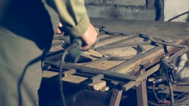 Travailleur de gros plan utilisant une meuleuse industrielle sur des pièces de voie ferrée en métal dans un entrepôt d'atelier industriel . — Video