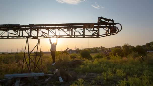 Un jeune homme tire sur une flèche horizontale en métal à l'air libre. Entraînement au soleil de l'Est — Video