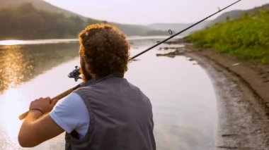 Nehri üzerinde bir sakal balıkçılık ile kıvırcık adam
