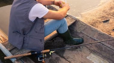 Genç bir çocuk bir elma bir ahşap teknede yiyor.