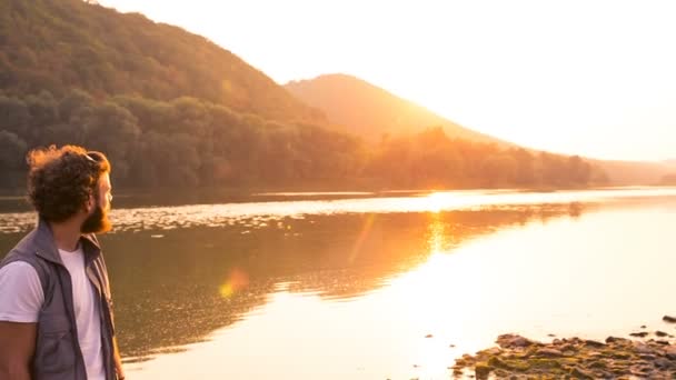 Feliz pescador sonríe al atardecer cerca del río — Vídeos de Stock