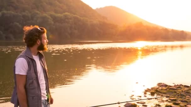 Joven pescador en una cálida noche de verano al atardecer . — Vídeos de Stock