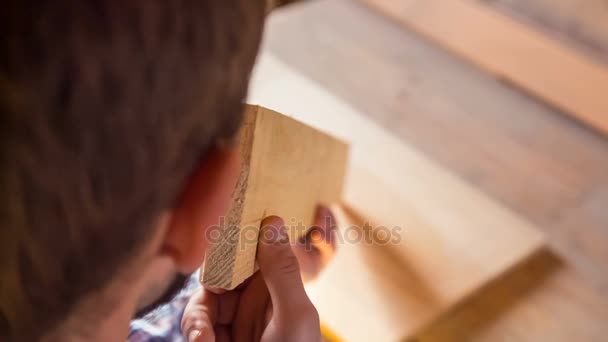 El joven carpintero inspecciona la igualdad de la madera — Vídeos de Stock