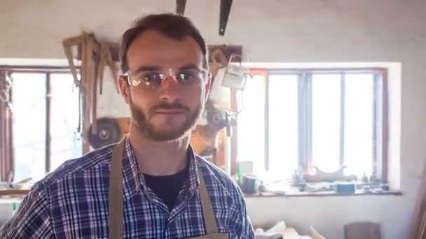 Úspěšné carpenter se usmívá na jeho pracovišti. Mladí profesionální svého podnikání — Stock video