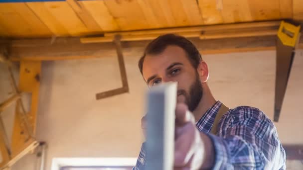 Carpenter kontroluje dřevěný hranol v truhlářské dílny. — Stock video