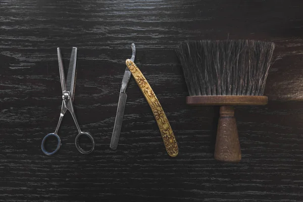 Vintage tools of barber shop on wooden background. Electric hair trimmer, vintage straight razors, a comb, wax and brush on the wooden background, close-up. Place to insert your text. Hipster grooming