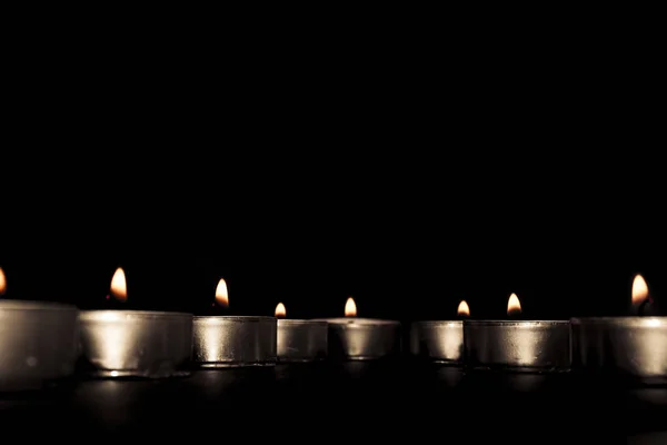 Luci di candela. Candele di Natale accese di notte. Candele astratte sfondo. Luce dorata di fiamma di candela . — Foto Stock