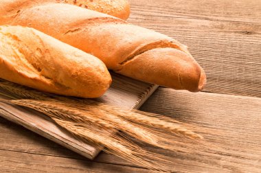 Ekmek, baget, somun ve ahşap masa üzerine buns. Yatay