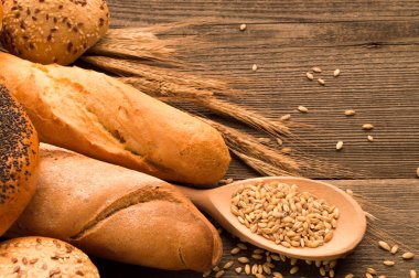 Tahıl, ekmek ve buns ahşap masa üzerine kaşıkla