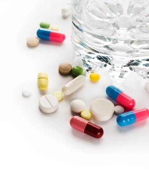 Медицина. Кольорові таблетки зі склянкою води — стокове фото