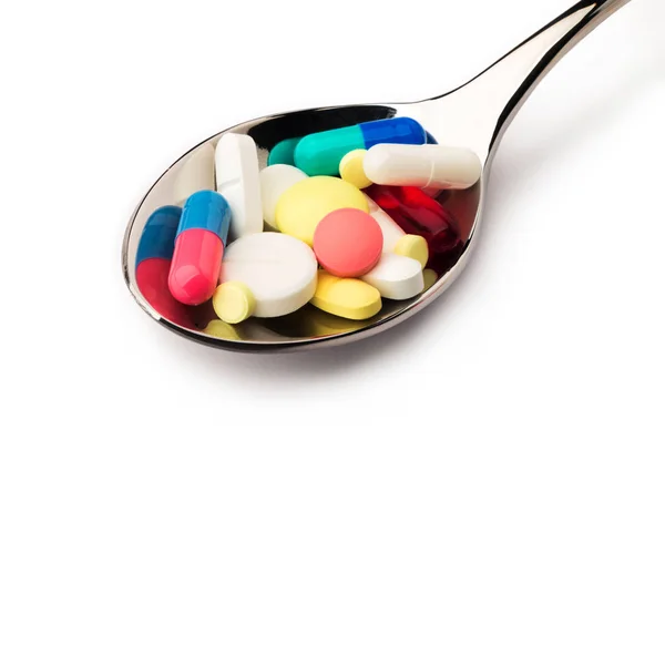 Enfermedad. Un montón de pastillas en cuchara —  Fotos de Stock
