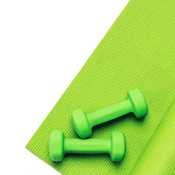 Fitness-Konzept - grüne Yogamatte und Kurzhanteln — Stockfoto