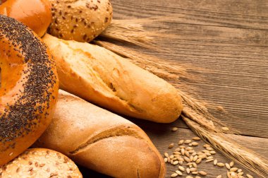 Ekmek, baget, somun ve ahşap masa üzerine buns. Yatay